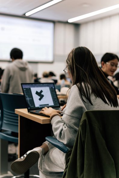 A participant coding on a laptop during the event