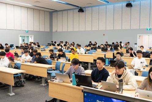 Participants working at desks across a lecture hall